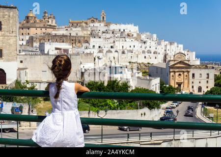 Italien, Apulien, Ostuni, kleines Mädchen suchen Altstadt Stadtbild Stockfoto