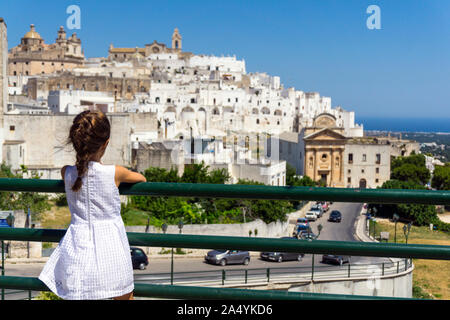 Italien, Apulien, Ostuni, kleines Mädchen suchen Altstadt Stadtbild Stockfoto