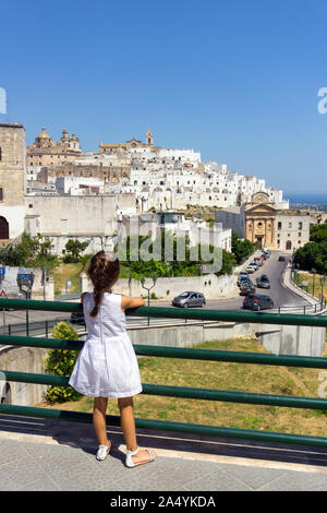 Italien, Apulien, Ostuni, kleines Mädchen suchen Altstadt Stadtbild Stockfoto