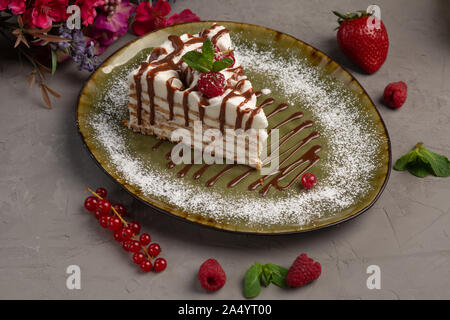 Mandel millefeuille Eistorte mit Mandel- und Beeren in einer grünen Platine auf grauem Hintergrund Stockfoto