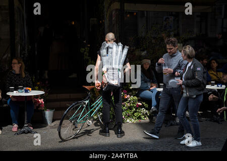 Ein Radfahrer mit einem Beutel der Plastikbecher auf oranienstraße am 1. Mai 2019 in Berlin, Deutschland Stockfoto