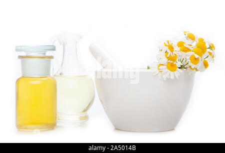 Ätherisches Öl, mit Blumen und natürlichen Kräutern. Mörtel mit Medizin Glas frischen Kräutern und ätherischen Öl Flasche. Stockfoto