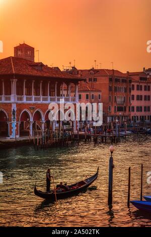 Venedig, Italien - Oktober 13, 2019: Schöne Aussicht der traditionellen Gondel auf berühmten Canal Grande im goldenen Abendlicht bei Sonnenuntergang in Venedig, Italien. Stockfoto