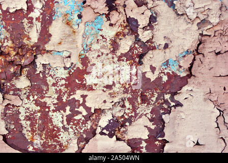 Rusty geknackt rosa-gelbe Farbe Oberfläche mit Türkis details Close up, Grunge horizontale schäbig Hintergrund Stockfoto