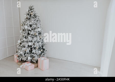 Weihnachtsbaum mit Geschenken im weißen Zimmer im neuen Jahr Santa Stockfoto