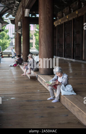Alte asiatische Frauen lesen Kyoto Tempel Einführung Broschüre. Gesunde grand ma Besuch allein japanische Stadt, Kyoto, Japan, 29-7-19 Stockfoto
