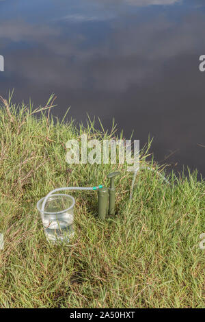 Überleben Fähigkeiten. Persönliche 1 Mikron Keramik Wasserfilter Luftreiniger von River Bank. Trinkwasser outlet grün markiert. Reines Wasser Konzept not Wasser Stockfoto