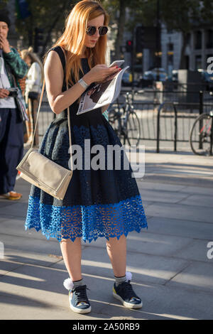 LONDON, Großbritannien - 13 September 2019: Leute auf der Straße, während der London Fashion Week. Mädchen mit kleinen Zöpfen in ein rosa Kleid Shirt mit einem transparenten Stockfoto