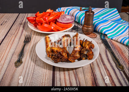 Lamm Rippen mit Gewürzen mariniert Gegrillte in einem Teller auf dem Tisch. Mit in Scheiben geschnittenen Tomaten, Paprika und Zwiebeln Stockfoto
