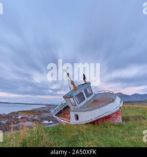 Eine gestrandete Fischerboot auf den Lofoten. Starker Wind weht durch die Landschaft. Stockfoto