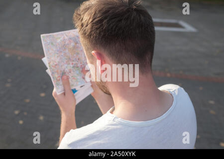 Kaukasischen jungen Mann Tourist auf der Straße mit einem Guide in der neuen Stadt verloren Stockfoto