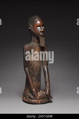 Männliche Figur, Ende 1800 - Anfang 1900. Dieses Objekt ist eine von nur zwei Sitzen männliche Beembe Zahlen einer solchen Größe im Westen erhalten; das andere ist in das Ethnographische Museum der Universität Zürich, Schweiz. Sie konnten verehrt Vorfahren vertreten haben und funktioniert in einer Sekte in ihrer Ehre, aber uns fehlt jeder primären Informationen, solche Hypothesen zu unterstützen. Ein Feld Foto im Jahre 1926 von einem schwedischen Missionar genommen wird, zeigt eine dritte Skulptur der gleichen Größe liebevoll von einem Beembe Mann, der vor, was einer uralten Heiligtum werden könnten. Denn es fehlt die typische Abdominal- scarification Stockfoto