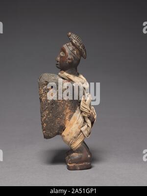 Männliche Figur, Ende 1800 - Anfang 1900. Diese menschliche-förmige nkisi in Yombe Stil &#x2014; eines der typischen Formen ein Geist Container unter Kongo Redner in West nehmen können - Zentrales Afrika &#x2014; verfügt über eine enorme Spiegel-Paket auf seinen Magen, der erstaunlich intakt ist, was bedeutet, dass die Abbildung nicht vor Verkauf oder Entsorgung stillgelegt. Das Tuch Bands und Knoten Schleife um den Hals und auf dem Rücken und um seine Beine fester deuten darauf hin, dass es zu binden, Vereinbarungen oder Eide verwendet wurde. Am faszinierendsten ist das Schnitzen eines pangolin oder schuppigen Ameisenbär auf dem Kopf, die dazu führen, stellt Stockfoto