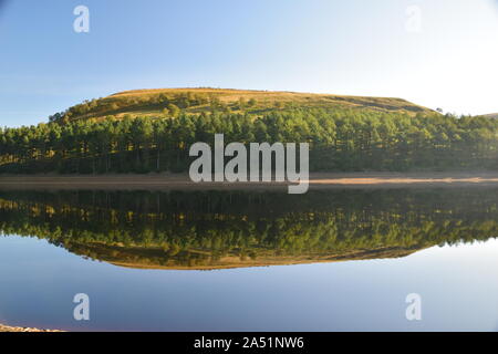 Howden Reservoir derbyshire england, das den Himmel und die Ufer zeigte, die sich Mitte Sommer auf der Stillwasseroberfläche niederschlugen Stockfoto