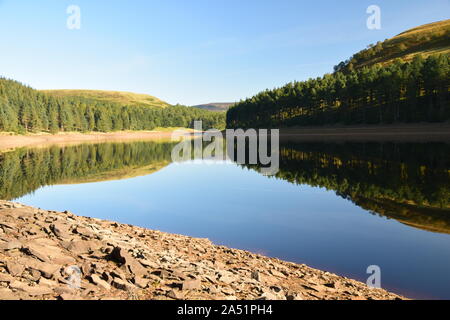 Howden Reservoir derbyshire england, das den Himmel und die Ufer zeigte, die sich Mitte Sommer auf der Stillwasseroberfläche niederschlugen Stockfoto