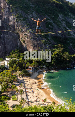 Slackliner zu Fuß auf Highline mit schöner Landschaft und Zuckerhut auf der Rückseite, Rio de Janeiro, Brasilien Stockfoto