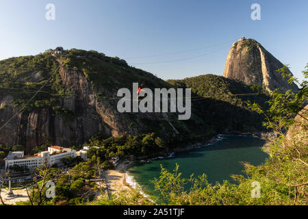 Slackliner zu Fuß auf Highline mit schöner Landschaft und Zuckerhut auf der Rückseite, Rio de Janeiro, Brasilien Stockfoto