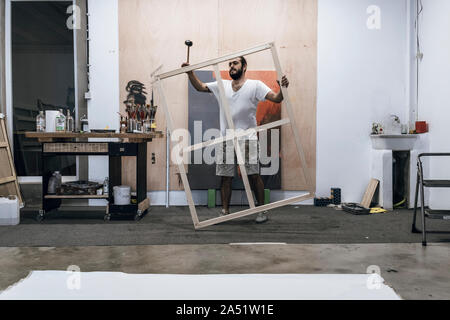 Junge Maler arbeiten Vorbereiten des Holzes und die Leinwand auf der Fi-Farbe Stockfoto