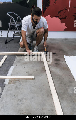 Junge Maler arbeiten Vorbereiten des Holzes und die Leinwand auf der Fi-Farbe Stockfoto