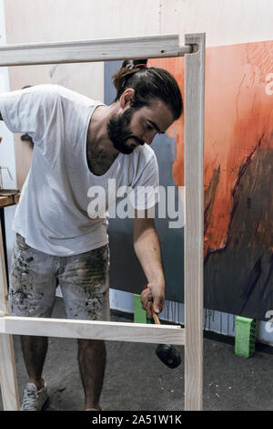 Junge Maler arbeiten Vorbereiten des Holzes und die Leinwand auf der Fi-Farbe Stockfoto