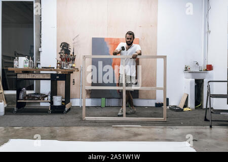 Junge Maler arbeiten Vorbereiten des Holzes und die Leinwand auf der Fi-Farbe Stockfoto