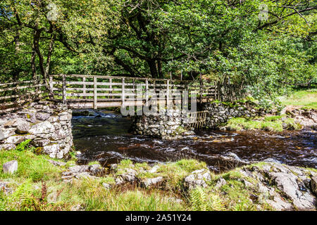 Ein Holzsteg über watendlath Beck im Nationalpark Lake District, Cumbria. Stockfoto