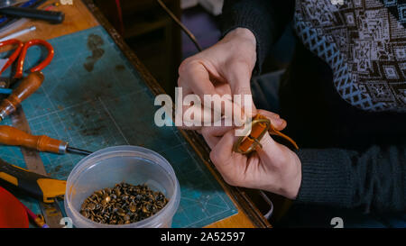 Skinner arbeiten mit Leder Gürtel Stockfoto