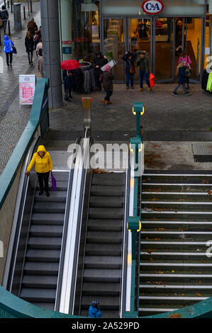 Berlin, Deutschland - 5. Oktober 2019: Street Scene in Berlin mit dem Eingang eines Kaufhauses neben dem Eingang zur U-Bahnstation an einem regnerischen Herbst Stockfoto