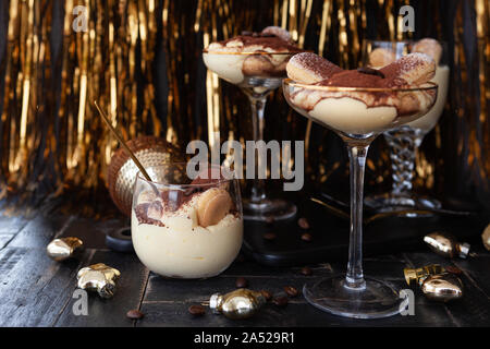 Festliche Tiramisu Dessert in Gläser mit goldenen Dekorationen für die Feiertage Stockfoto