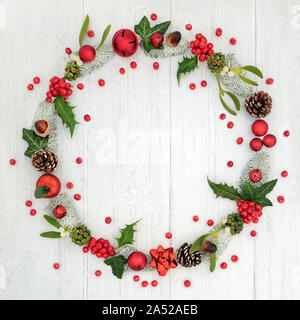 Christmas wreath Dekoration mit lose Stechpalme Beeren und Winter Flora auf rustikalem Holz Hintergrund mit kopieren. Stockfoto