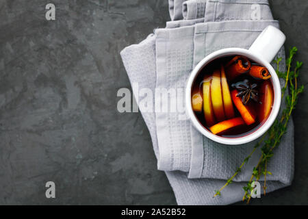 Weihnachten heißer Glühwein oder Glühwein trinken in eine Schale mit Zitrusfrüchten, Apple, Zimtstangen und Anis auf Dunkelgrau konkreten Hintergrund der Ansicht von oben kopieren Raum Stockfoto