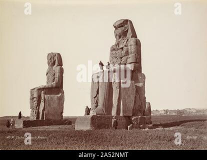 Theben, die Kolosse von Memnon, 1870. Da immer mehr Fotografen die gleiche Denkmäler schoß, Darstellungen wurde formelhaft. Zahlreiche Fotografen fast identische Bilder produziert, wie in diesen zwei Ansichten der Kolosse von Memnon demonstriert. Von verschiedenen Seiten aber etwa die gleiche Entfernung erschossen, beide Bilder beschäftigen eine abgewinkelte ansehen und ägyptischen Bediensteten und führt als lokale Farbe und Indizes zu verwenden. Bildunterschriften und Künstler &#x2019; Unterschriften wurden oft in umgekehrter auf das Negative geschrieben, so dass Sie automatisch Teil jeder Seite drucken. Manchmal, wie im Beato Bild, der Künstler oder seine assistan Stockfoto