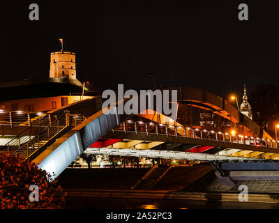 Gediminas Turm in Vilnius, Litauen, bei Nacht mit Mindaugas Brücke über den Fluss Neris im Vordergrund. Stockfoto