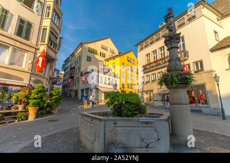 Brunnen in Lindenhof von schweizer Fahnen hängen von Gebäuden umgeben, Zürich, Schweiz Stockfoto