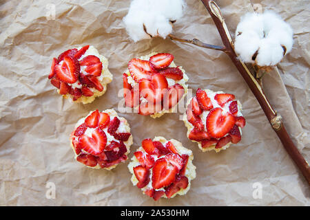 Sehr lecker Muffins mit frischen Erdbeeren liegen auf Kraftpapier. Stockfoto