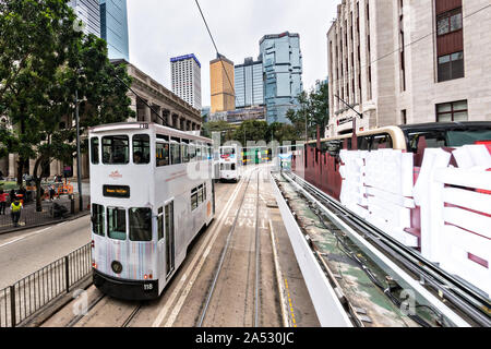 Historische Doppeldecker Straßenbahnen Pässe Statue Square im Central District von Hong Kong. Stockfoto