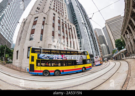 Fischaugenobjektiv ein Double Decker Bus Reisen vorbei an der alten Bank von China Gebäude im Central District von Hong Kong. Stockfoto