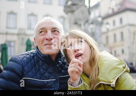 Im freien Portrait von älteren Mann und seine junge blonde Frau Ausgabe Zeit zusammen in der alten Stadt im frühen Frühjahr oder Herbst. Paar mit Alter Stockfoto