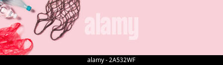 Plastikbeutel mit mesh textile Tasche von Plastikflaschen und auf rosa Hintergrund umgeben. Flach, Ansicht von oben. Stockfoto