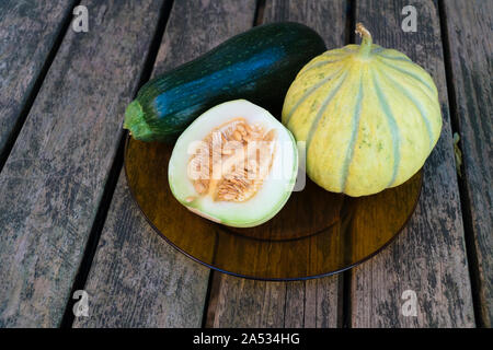 Gentechnikfreie Melonen und Zucchini auf einem Holztisch Stockfoto