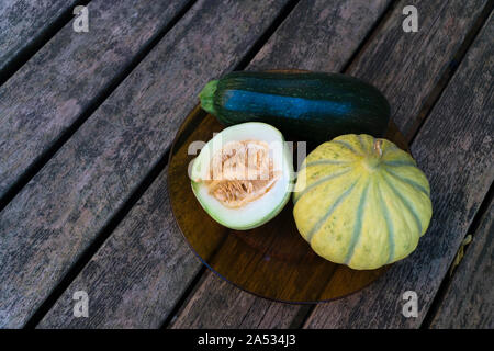 Gentechnikfreie Melonen und Zucchini auf einem Holztisch aus direkt über Stockfoto