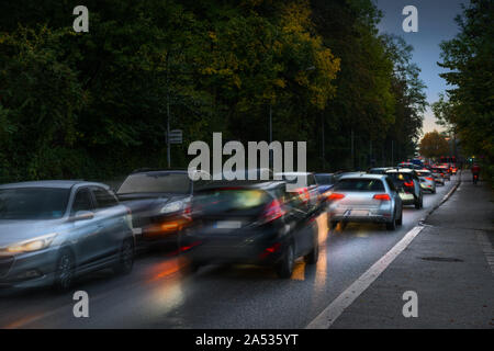 Bremsen Autos bei rush hour Jam in einer dunklen Gasse in die Stadt mit nassem Asphalt, auf dem Weg zur Arbeit am frühen Morgen, Bewegungsunschärfe, Kopie spa Stockfoto