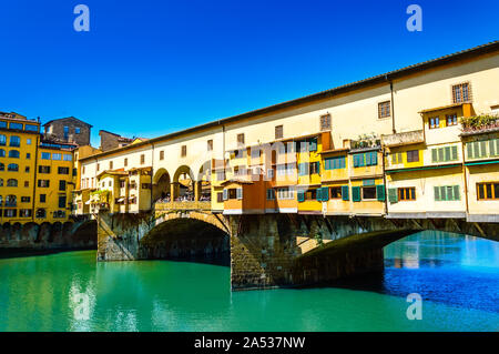 Ponte Vecchio oder die Alte Brücke über den Fluss Arno in Florenz, Italien. Bogenbrücke mit Schmuck und Kunst Geschäfte und farbenfrohe Gebäude ist eine berühmte touristische Stockfoto