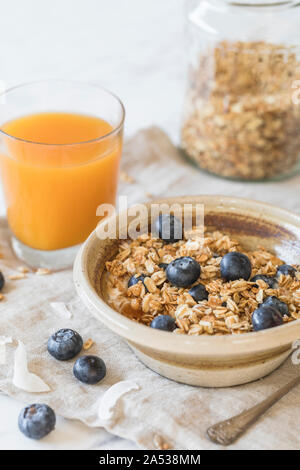 Ein frisches und gesundes Frühstück mit Müsli Müsli, frischen Heidelbeeren und Orangensaft, Müsli und ein jar. Close-up vertikale Ansicht. Stockfoto