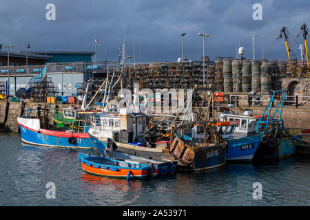 Wellen von Licht während des herannahenden Sturm leuchtet die Schar der Boote in Brixham Inner Harbour im Monat Oktober Stockfoto