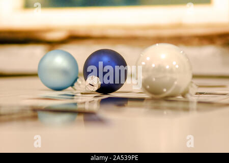 Drei Christbaumkugeln liegen auf glänzende Oberfläche Stockfoto