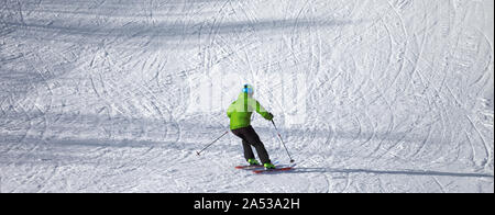 Skifahrer Abstieg auf verschneiten Skipiste mit Kurven von Skier an sonnigen Wintertag. Kaukasus Berge. Hatsvali, Swaneti Region Georgiens. Panoramablick. Stockfoto