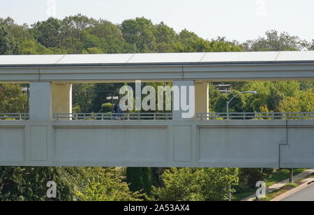 Arlington, VA/USA - 22. September 2019: Studentin Spaziergänge auf einer Überführung Brücke an Marymount University Stockfoto