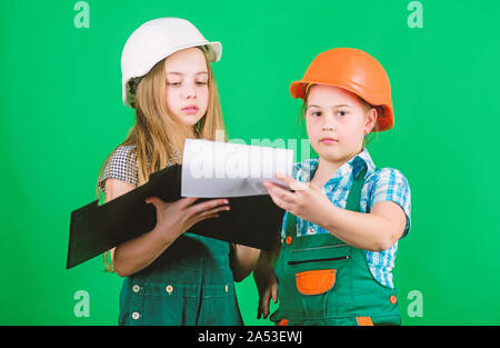 Kleine Mädchen zusammen die Reparatur in der Werkstatt. Schulprojekt. Glückliche Kinder. Kleine Kinder im Helm mit Tablet. Tag der Arbeit. 1. Mai. Meister Inspektor. Reparatur. building Workshop. workshop Arbeitnehmer. Stockfoto