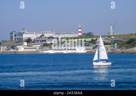 Eine weiße Yacht segelt in Plymouth Sound der legendären Plymouth Hoe. Stockfoto